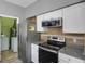 Kitchen features modern stainless steel appliances including a microwave and range oven at 470 Regal Downs Cir, Winter Garden, FL 34787