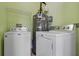 Well-equipped laundry room with washer, dryer, and water heater, creating a functional utility space at 470 Regal Downs Cir, Winter Garden, FL 34787