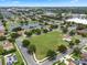 An aerial view captures a neighborhood with a large field, playground, pond, and a variety of homes at 470 Regal Downs Cir, Winter Garden, FL 34787