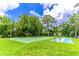 An outdoor basketball court, pickleball court, and lush green space beneath a blue, partly cloudy sky at 489 Meadowood Blvd, Fern Park, FL 32730