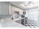 Stylish kitchen with white cabinets, marble countertops, and checkerboard floors at 489 Meadowood Blvd, Fern Park, FL 32730