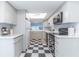 Eat-in kitchen with updated appliances, gray cabinets, and checkerboard flooring at 489 Meadowood Blvd, Fern Park, FL 32730