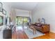 Cozy living room featuring hardwood floors, stylish furniture, and a screened patio at 489 Meadowood Blvd, Fern Park, FL 32730
