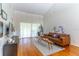 Bright living room with hardwood floors, modern furnishings, and natural light streaming in through large windows at 489 Meadowood Blvd, Fern Park, FL 32730