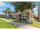 View of the two-story home with stone veneer, manicured landscaping, tree, and a sidewalk in front at 5217 Creekside Park Ave, Orlando, FL 32811