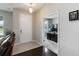 Bright entryway with tile flooring, white front door and a glimpse into a home office with desk at 5217 Creekside Park Ave, Orlando, FL 32811