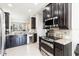 Modern kitchen features dark cabinets, stainless steel appliances, granite counters, and tile flooring at 5217 Creekside Park Ave, Orlando, FL 32811
