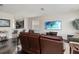 Open-concept living room with hardwood floors, a comfortable leather sofa, and a view to the kitchen at 5217 Creekside Park Ave, Orlando, FL 32811