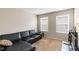 Comfortable living room with a large sectional sofa and natural light from the two windows at 5217 Creekside Park Ave, Orlando, FL 32811
