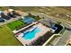 An aerial view showcasing a community pool, tennis courts, green space, and residential buildings at 5308 Citrus Leaf Blvd, Winter Garden, FL 34787