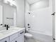 Bright bathroom featuring a modern vanity with black hardware and a tub with white tile surround at 5308 Citrus Leaf Blvd, Winter Garden, FL 34787