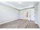 Light-filled bedroom with wood-look floors, tray ceiling and closet and adjoining bath at 5308 Citrus Leaf Blvd, Winter Garden, FL 34787