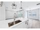 Kitchen island with stainless steel sink, modern fixtures, and a view to the great room beyond at 5308 Citrus Leaf Blvd, Winter Garden, FL 34787