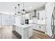 Modern kitchen with white cabinets, stainless steel appliances, and island with quartz countertops at 5308 Citrus Leaf Blvd, Winter Garden, FL 34787