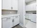 Functional laundry room with ample cabinet space, quartz countertops, and modern washer and dryer at 5308 Citrus Leaf Blvd, Winter Garden, FL 34787
