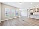 Bright, open-concept living room featuring wood flooring, and a modern kitchen with stainless steel appliances at 5308 Citrus Leaf Blvd, Winter Garden, FL 34787