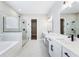 Bright main bath featuring dual vanity, marble floors, glass shower, and soaking tub at 5308 Citrus Leaf Blvd, Winter Garden, FL 34787
