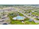 Aerial view of a community pool and clubhouse, with an adjacent parking lot and recreation area at 622 Taft Dr, Davenport, FL 33837