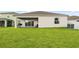 Backyard view featuring a covered patio and a spacious green lawn, perfect for outdoor activities at 622 Taft Dr, Davenport, FL 33837