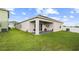 A well-maintained backyard with a covered patio, seating area, and lush green lawn at 622 Taft Dr, Davenport, FL 33837