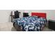 This bedroom features tile flooring, a red headboard, a blue and white comforter and black nightstands at 622 Taft Dr, Davenport, FL 33837