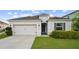 Inviting single-story home with a manicured lawn and two-car garage, featuring a welcoming entrance at 622 Taft Dr, Davenport, FL 33837