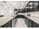 Spacious kitchen with dark cabinets, stainless steel appliances, granite countertops, and tile flooring at 622 Taft Dr, Davenport, FL 33837