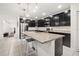 Modern kitchen featuring a large center island, stainless steel appliances, and dark cabinetry at 622 Taft Dr, Davenport, FL 33837