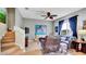 Living room features a fan, window with curtains, painting on the wall, stairs and decor at 6462 S Goldenrod Rd # 31B, Orlando, FL 32822