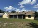 Exterior back view featuring a large screened patio and a spacious yard at 6610 Pampus Dr, Orlando, FL 32819