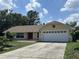 Inviting single-story home with a well-maintained lawn and a two-car garage under a blue sky at 6610 Pampus Dr, Orlando, FL 32819