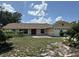 Charming single-story home featuring a red front door, two-car garage and lush greenery in a tranquil setting at 6610 Pampus Dr, Orlando, FL 32819