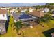 Back aerial view of home with solar panels, screened patio, and spacious grassy backyard at 826 Sheen Cir Cir, Haines City, FL 33844