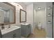 Bathroom featuring a double sink vanity, decorative mirrors, textured walls, and a toilet in separate space at 826 Sheen Cir Cir, Haines City, FL 33844