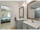 Bathroom featuring double sink vanity, textured wall panels, and a view through to the bedroom at 826 Sheen Cir Cir, Haines City, FL 33844