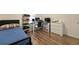 This bedroom has wood floors, a bed and work area with two computer monitors at 826 Sheen Cir Cir, Haines City, FL 33844