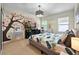 Bright bedroom with a decorative tree wall art feature and a comfy-looking bed with decorative pillows at 826 Sheen Cir Cir, Haines City, FL 33844