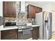 Stylish kitchen with stainless steel appliances, dark wood cabinets, and mosaic backsplash details at 826 Sheen Cir Cir, Haines City, FL 33844