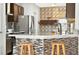 Close-up of the kitchen featuring marble countertops, tile backsplash, modern appliances, and breakfast bar seating at 826 Sheen Cir Cir, Haines City, FL 33844