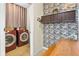 Well-appointed laundry room with stylish red machines, cabinet, decorative backsplash and wooden folding table at 826 Sheen Cir Cir, Haines City, FL 33844