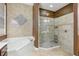 Elegant bathroom featuring a soaking tub, separate glass shower, and neutral tile at 827 Timber Isle Dr, Orlando, FL 32828