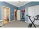 Bedroom with blue walls, exercise bike, and easy access to the bathroom at 827 Timber Isle Dr, Orlando, FL 32828