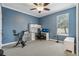 Bright bedroom with blue walls, ceiling fan, and window view, creating a cozy and functional space at 827 Timber Isle Dr, Orlando, FL 32828