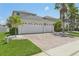 A home with a three car garage and paved driveway and lush landscaping, offering curb appeal and convenience at 827 Timber Isle Dr, Orlando, FL 32828