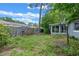 A wide shot of the backyard features a weathered wooden fence, grassy lawn, and partial view of the home's screened patio at 885 Little Bend Rd, Altamonte Springs, FL 32714