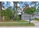 A house with a light gray garage door, surrounded by lush trees and manicured front yard; features a vintage green mailbox at 885 Little Bend Rd, Altamonte Springs, FL 32714