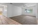 Bright, carpeted living room with an adjacent tiled bathroom and view of an enclosed porch at 885 Little Bend Rd, Altamonte Springs, FL 32714