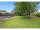 Large, grassy backyard featuring a screened-in pool and mature trees at 11648 Grand Bay Blvd, Clermont, FL 34711