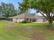 Spacious backyard with white exterior of home and screened-in lanai at 11648 Grand Bay Blvd, Clermont, FL 34711
