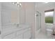 Bathroom with white vanity, toilet, and glass enclosed shower at 11648 Grand Bay Blvd, Clermont, FL 34711